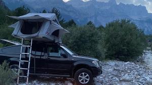a black truck with a tent on the top of it at car camping rental in Shkodër