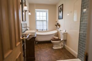 a bathroom with a tub and a toilet and a sink at Rosebank Cottage - Hot Tub & Log Stove in Alexandria