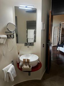 a bathroom with a large mirror and a sink at Castillo de Monte la Reina Posada Real & Bodega in Toro
