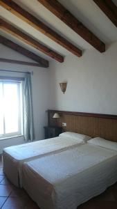 a bedroom with a large white bed with a window at El Olivar de Roche Viejo in Conil de la Frontera