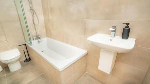 a bathroom with a sink and a toilet and a shower at The Cheltenham Suites - Collection of Luxury Flats in Cheltenham