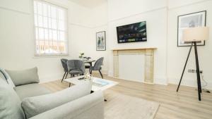 a living room with a couch and a table at The Cheltenham Suites - Collection of Luxury Flats in Cheltenham +64 photos