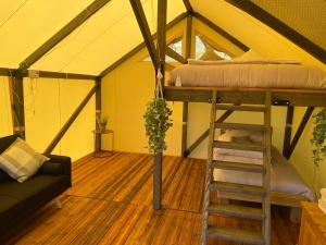 纽波特Usk View Glamping Caerleon的帐篷内带高架床的房间
