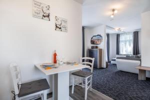 een kamer met een tafel en stoelen en een woonkamer bij Fewo Rosenhof TW 112 in Kühlungsborn