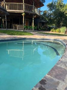 a large pool of blue water in front of a house at Kolobeng Cottages in Gaborone