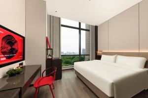 a bedroom with a large white bed and a red chair at Gwen Jane Hotel Free shuttle buses at the exhibition hall during the Canton Fair in Guangzhou