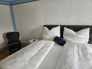 a bedroom with a bed with two pillows and a chair at DAS Donauhaus in Emmersdorf an der Donau