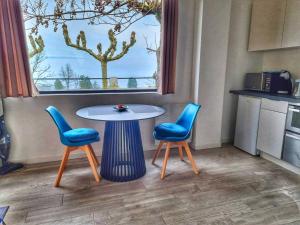 a table and two chairs in a room with a window at Appartement Cozy 2 Panoramique Lac Léman Thonon-Les-Bains in Thonon-les-Bains +3 photos