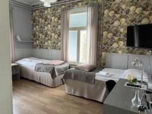 a bedroom with two beds and a window at Savonlinnan Kansanopisto - Wanha Pappila in Savonlinna