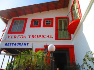 un edificio rojo y blanco con un cartel en él en Hotel Vereda Tropical, en Taboga