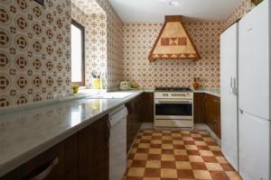 a kitchen with a checkered floor at Hospedería de La Corte in Corteconcepción
