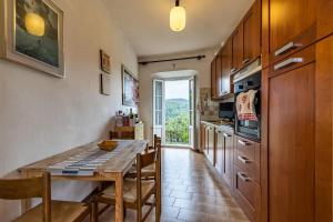 a kitchen with a wooden table and a dining room at Casa del Conte in Arto Centonara