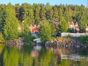 a group of houses next to a body of water at Saimaa Gardens Apartment near Beach in Rauha +11 photos