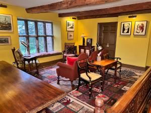 a living room with yellow walls and a table and chairs at Uplands Guest House in Ledbury