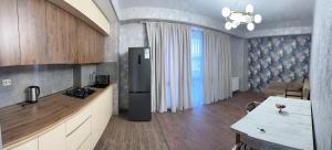 a kitchen with a refrigerator in the middle of a room at Nadikvari in Tbilisi City