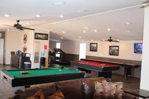 a billiard room with a couch and a pool table at Eagle Ford Village Suites in Dilley