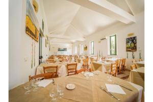a room filled with tables and chairs with white table linen at Family Village in Otranto