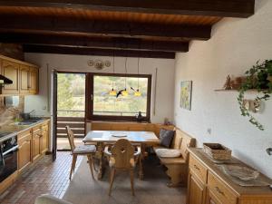 a kitchen with a table and a dining room at Ferienhaus Eifelhöhe mit Maarpanorama in Schalkenmehren