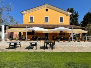 a house with tables and umbrellas in front of it at Agriturismo Ae Noseare in Torri di Quartesolo