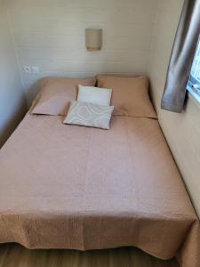 a bed with a pillow on it in a small room at Gîte Sous le Tilleul in Saint-Florent-le-Vieil