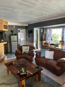 a living room with leather couches and a table at Garden View Inn in Cape Town