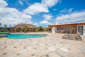 Un patio con piscina y una casa. en Volcanoa, en Villaverde