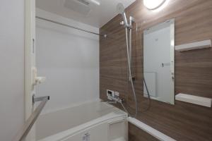 a bathroom with a shower and a mirror at Reve Asakusa in Tokyo