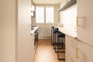 Una cocina con gabinetes blancos y una encimera con taburetes. en Mat&Ness Luxury, en Beauvais 9 fotos más