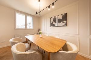 Un comedor con mesa y sillas de madera. en Mat&Ness Luxury, en Beauvais