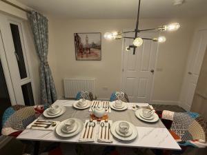 a dining room table with plates and utensils on it at Loch Ness Hideaway in Inverness