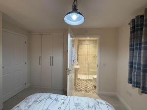a bedroom with a bed and a bathroom with a shower at Loch Ness Hideaway in Inverness