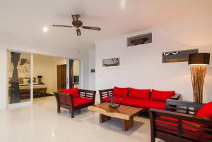 a living room with a red couch and a table at 3BR Villa3 Oberoi Seminyak,18Min walk to the beach in Seminyak