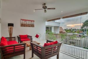 a living room with red pillows on a balcony at 3BR Villa3 Oberoi Seminyak,18Min walk to the beach in Seminyak