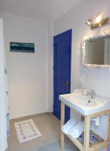 a bathroom with a sink and a blue door at Rhodes Summer House in Gennadi