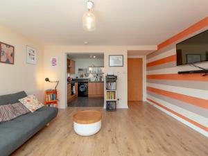 a living room with a couch and a striped wall at Modern 2-Bdr Flat in Edinburgh - Pass the Keys in Edinburgh
