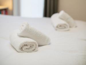 two rolls of white towels sitting on a bed at Modern 2-Bdr Flat in Edinburgh - Pass the Keys in Edinburgh