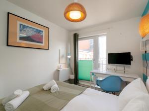 爱丁堡Modern 2-Bdr Flat in Edinburgh - Pass the Keys的一间卧室，里面有一张床、一张桌子和一台电视。