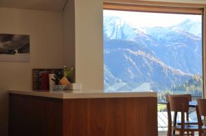VellaにあるPanoramic Ecodesign Apartment Obersaxen - Val Lumnezia I Vella - Vignogn I near Laax Flims I 5 Swiss stars ratingのキッチン(山の景色を望む大きな窓付)