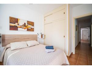 sypialnia z białym łóżkiem i obrazem na ścianie w obiekcie Apartamento 2H Zahara Mar w mieście Zahara de los Atunes +21 zdjęć