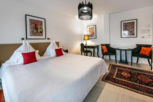 セーケシュフェヘールヴァールにあるBoutique Hotel Szárcsaの大きな白いベッドと赤い枕のある寝室