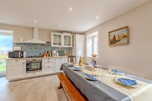 a kitchen with a long table with blue and white at Ty Line - Plage à 300 m 1 500 m² de jardin in Lampaul-Plouarzel +7 photos