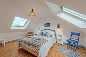 a bedroom with a bed and a blue chair at Ty Line - Plage à 300 m 1 500 m² de jardin in Lampaul-Plouarzel