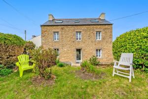 a brick house with two chairs in front of it at Ty Line - Plage à 300 m 1 500 m² de jardin in Lampaul-Plouarzel