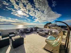 巴科利MH Suites Rooms Apartments的一个带沙发和椅子的庭院和大海