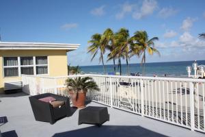 a balcony with a view of the ocean and palm trees at La Terrace Oceanfront in Hollywood