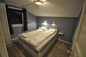 uma cama num quarto com uma parede azul em Etne Hytter em Etnesjøen