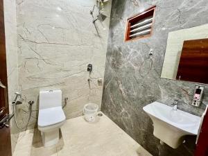 a bathroom with a white toilet and a sink at Hotel Moon in Una