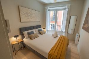 a bedroom with a large bed with a large window at Zapatería 30 by Clabao in Pamplona