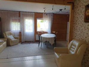 a living room with a table and chairs and a dining room at Kāpas in Jūrkalne