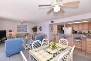 Una sala de estar con mesa y sillas y una cocina. en Holiday Villas II, en Clearwater Beach
